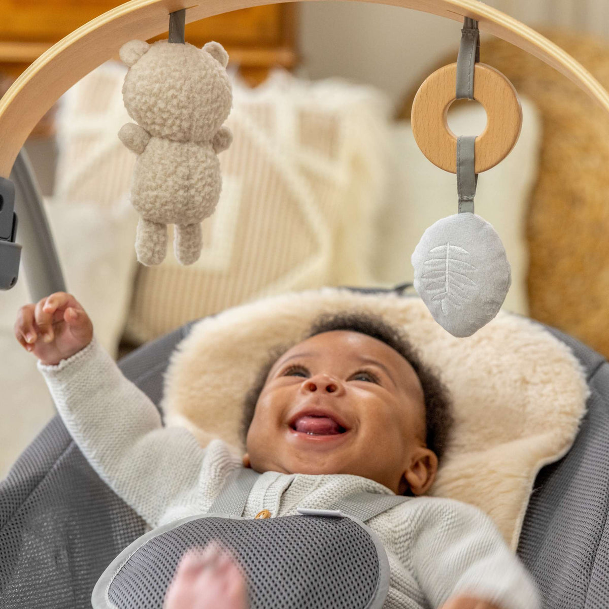 Cozy Ingenuity Baby Bouncer with soft fabric and interactive toys for soothing babies