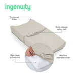 Ingenuity CozyClean Changing Pad with wipeable vinyl surface and removable washable cover in taupe on changing table