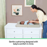 Ingenuity CozyClean Changing Pad taupe with wipeable vinyl surface and removable machine-washable cover on changing table