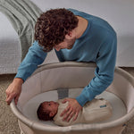 Man interacting with a baby in a bassinet