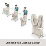 Ingenuity Snooze & Stow™ Easy-Folding Bassinet in sand with soothing sound, light, vibration, mesh sides, built-in shelf, and wheels for portable baby sleep