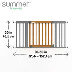 Ingenuity The Thruway 60W Series baby and dog safety gate with honey oak wood and metal frame installed in doorway